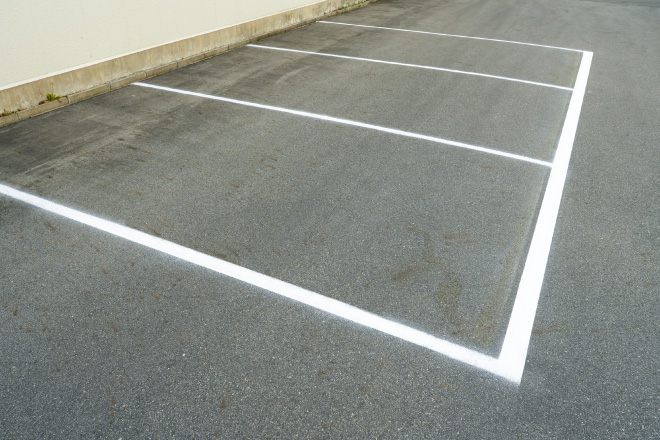 太線用の白で消えかかった駐車場の区画線を補修
